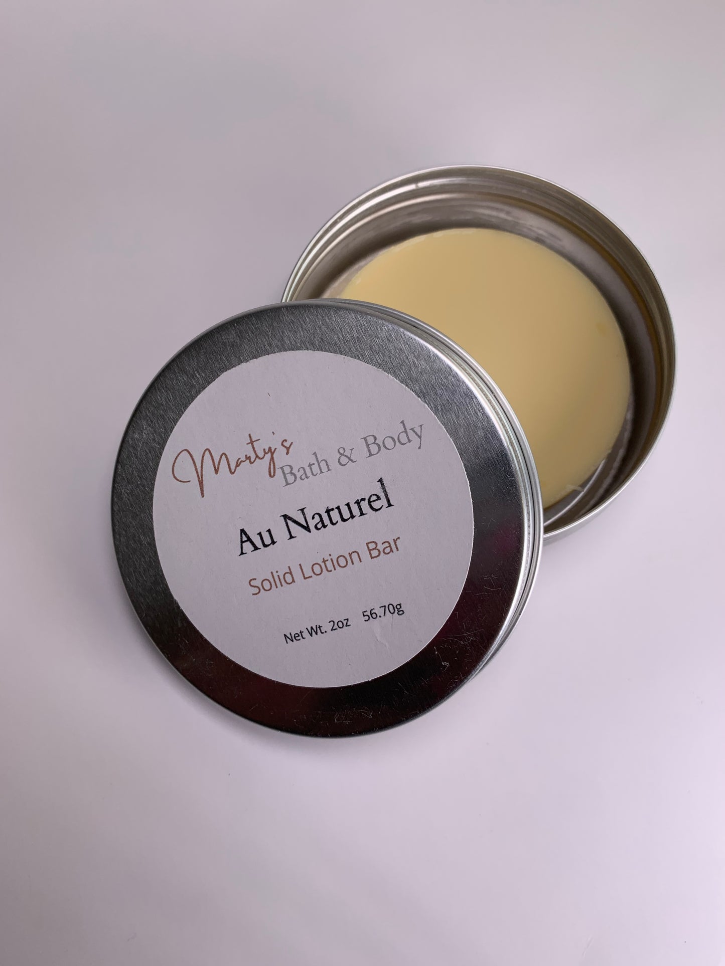 Au Naturel (unscented) all natural solid lotion bar and its recyclable container.