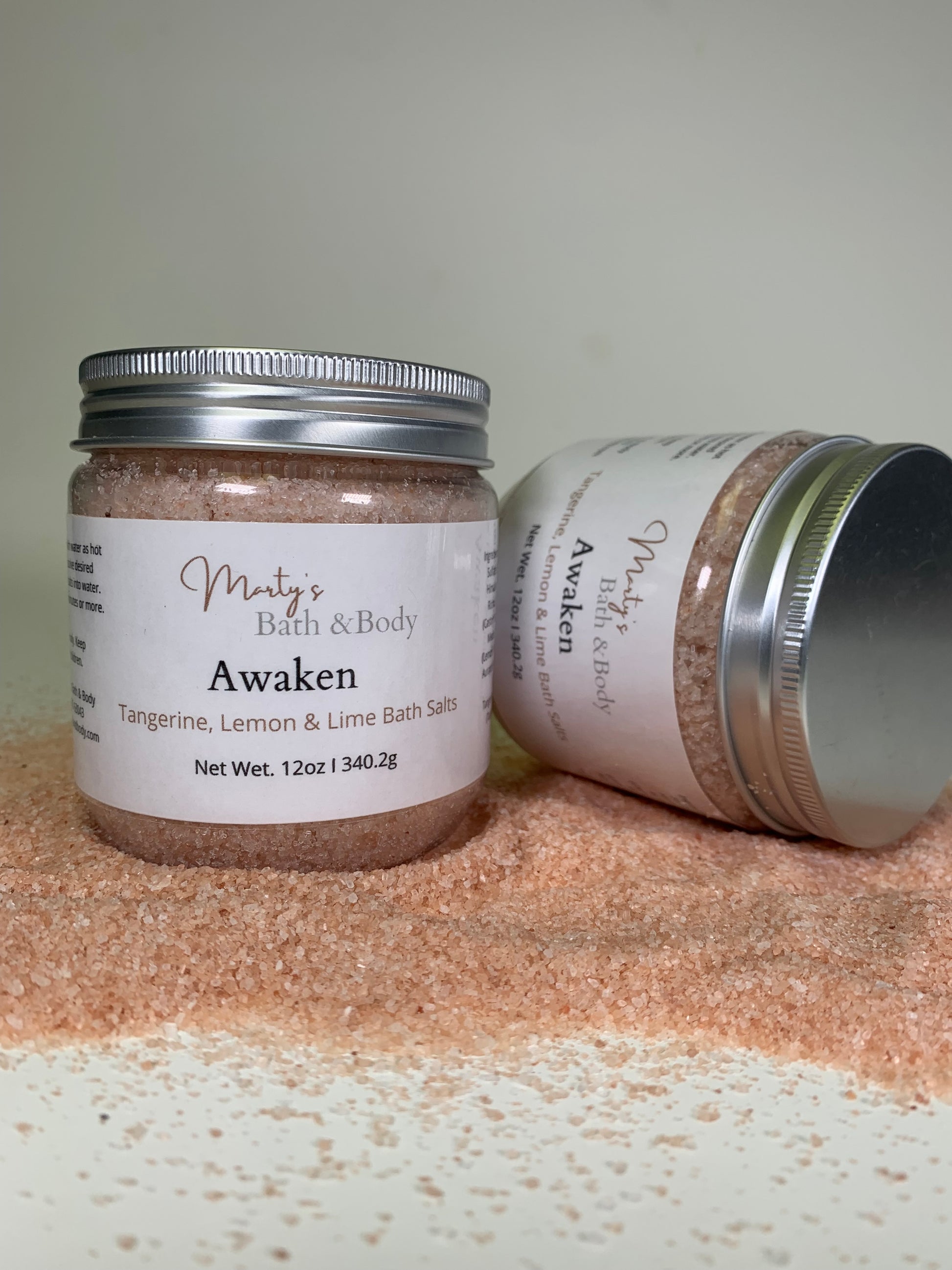 Two 12oz jars of Awaken citrusy scented bath salts/bath soaks.