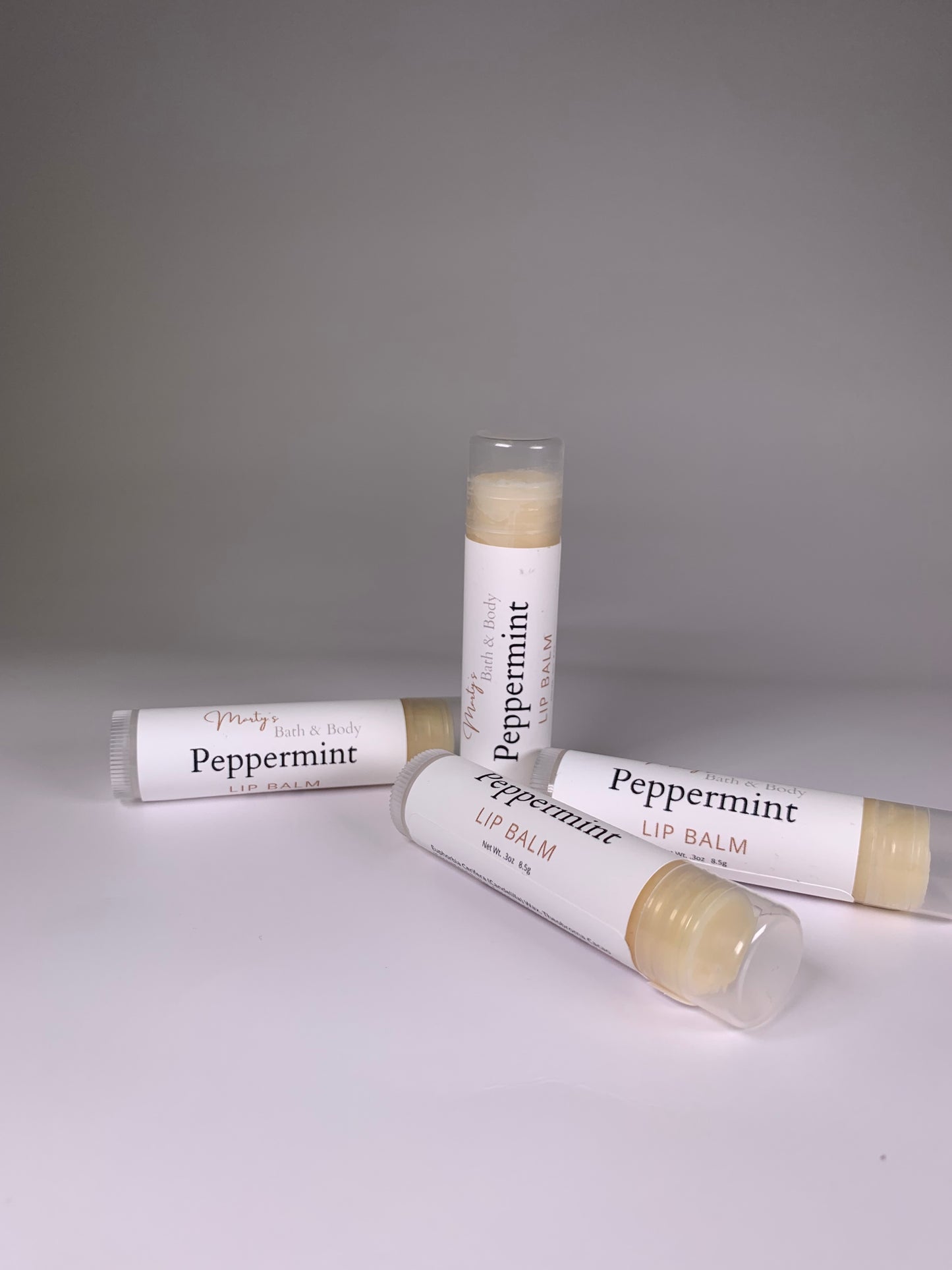 Four tubes of plant based, peppermint flavored lip balm.