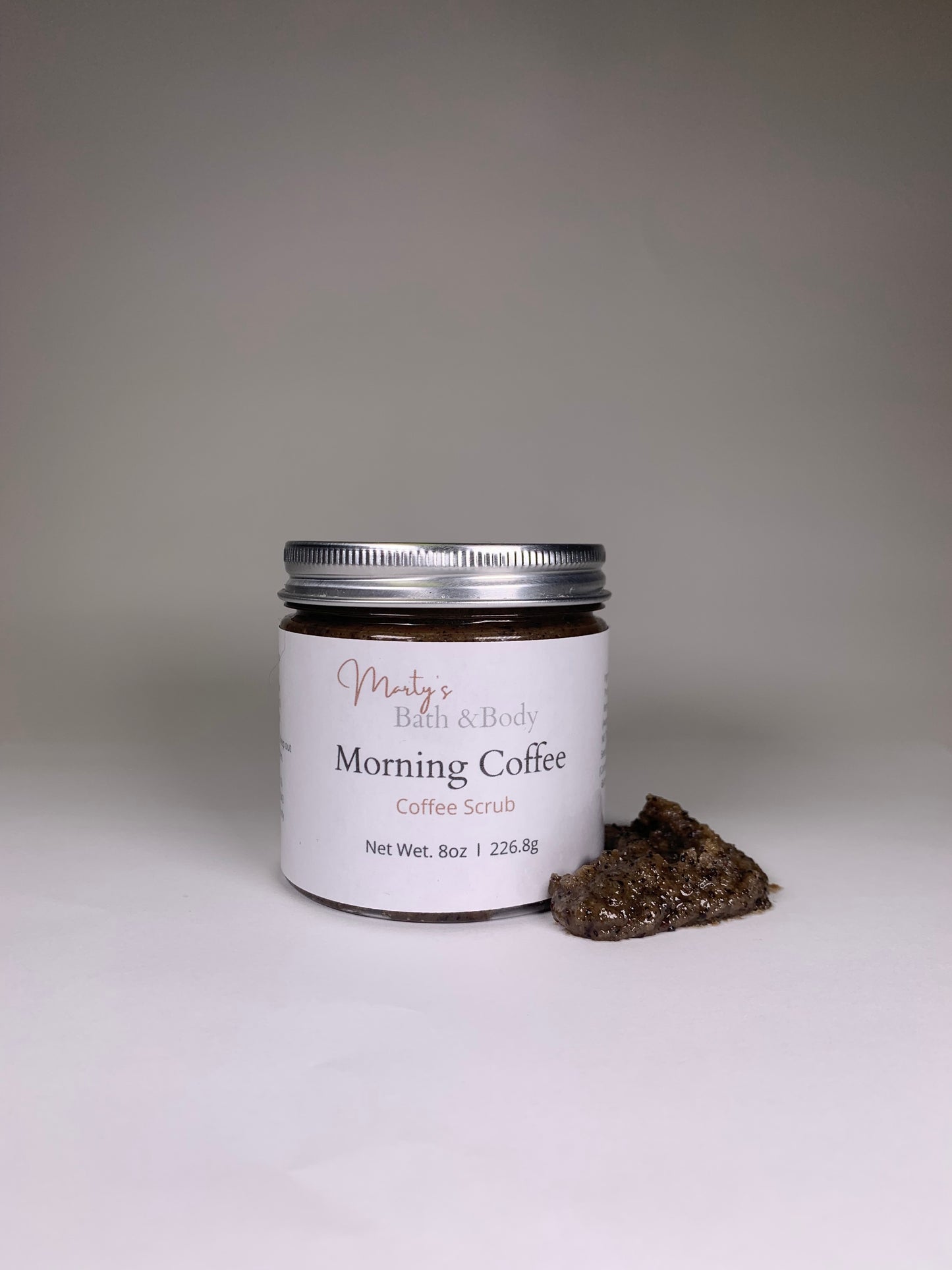 8oz jar of all natural Morning Coffee sugar scrub, with a sample of the scrub next to the jar.